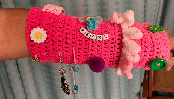 handmade sleeve with various buttons and patterns, with beads spelling pearl made by Alzheimer's patient as a distraction.