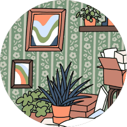 A wall covered in floral wallpaper with picture frames on the wall and potted plants and boxes on the ground.