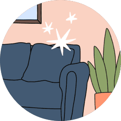 A plain colored couch and potted plant against a bare wall.